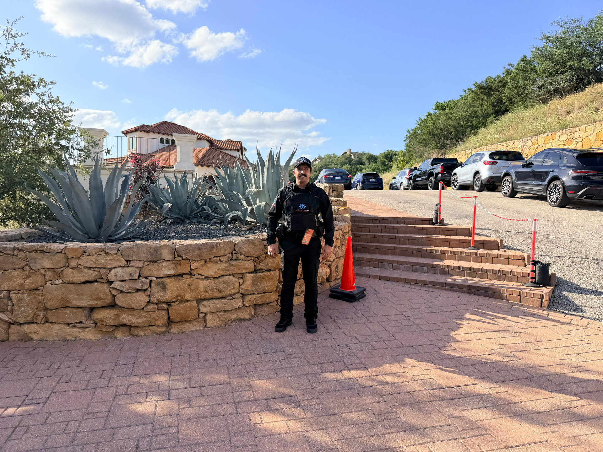 Level III Security Operations – armed officer covering the venue entry stairs and guest arrival path.