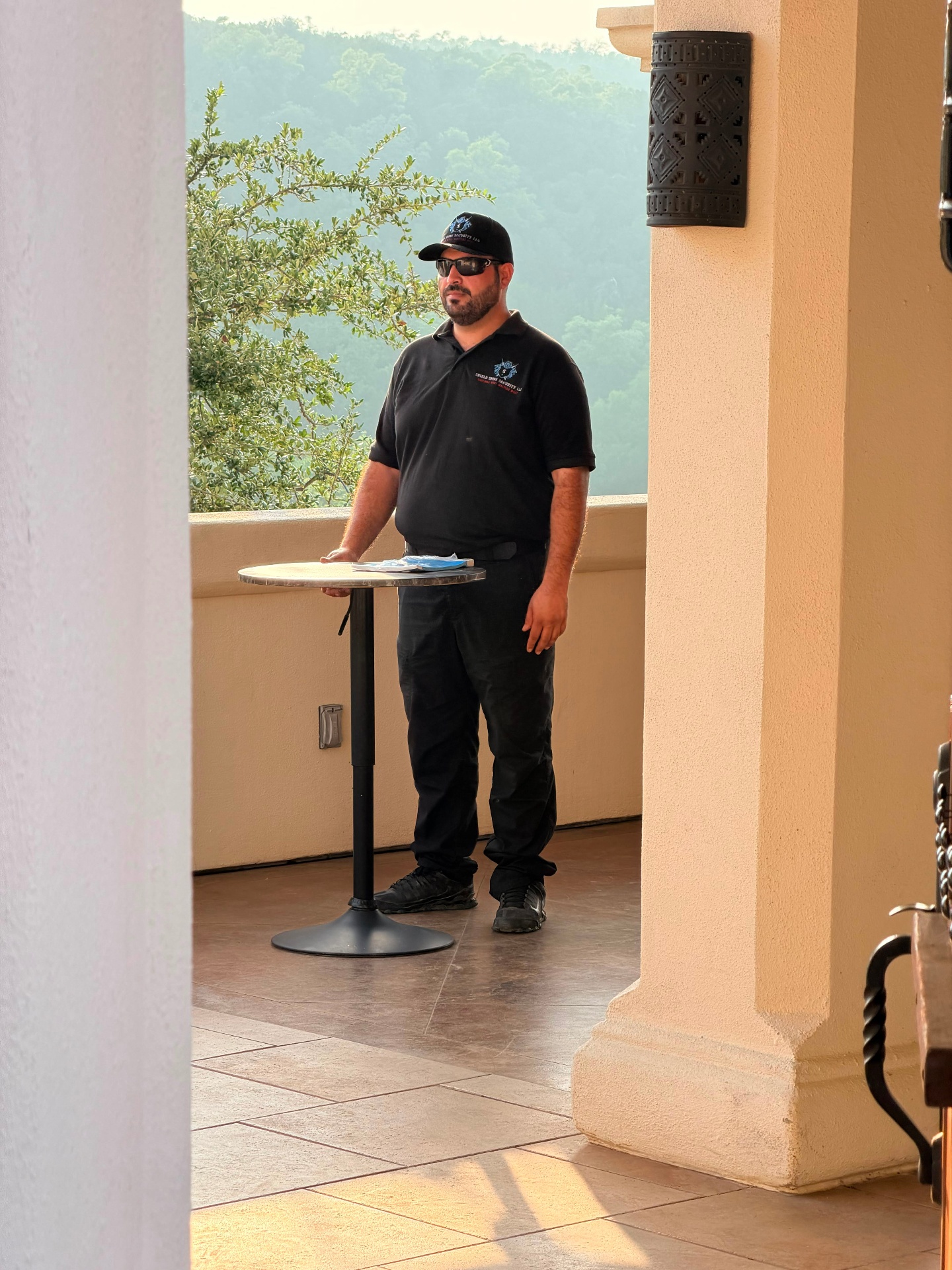 Oficial de Shield Spire Security junto a una mesa alta con vista a un recinto de eventos privados de categoría en Cedar Park, Texas.
