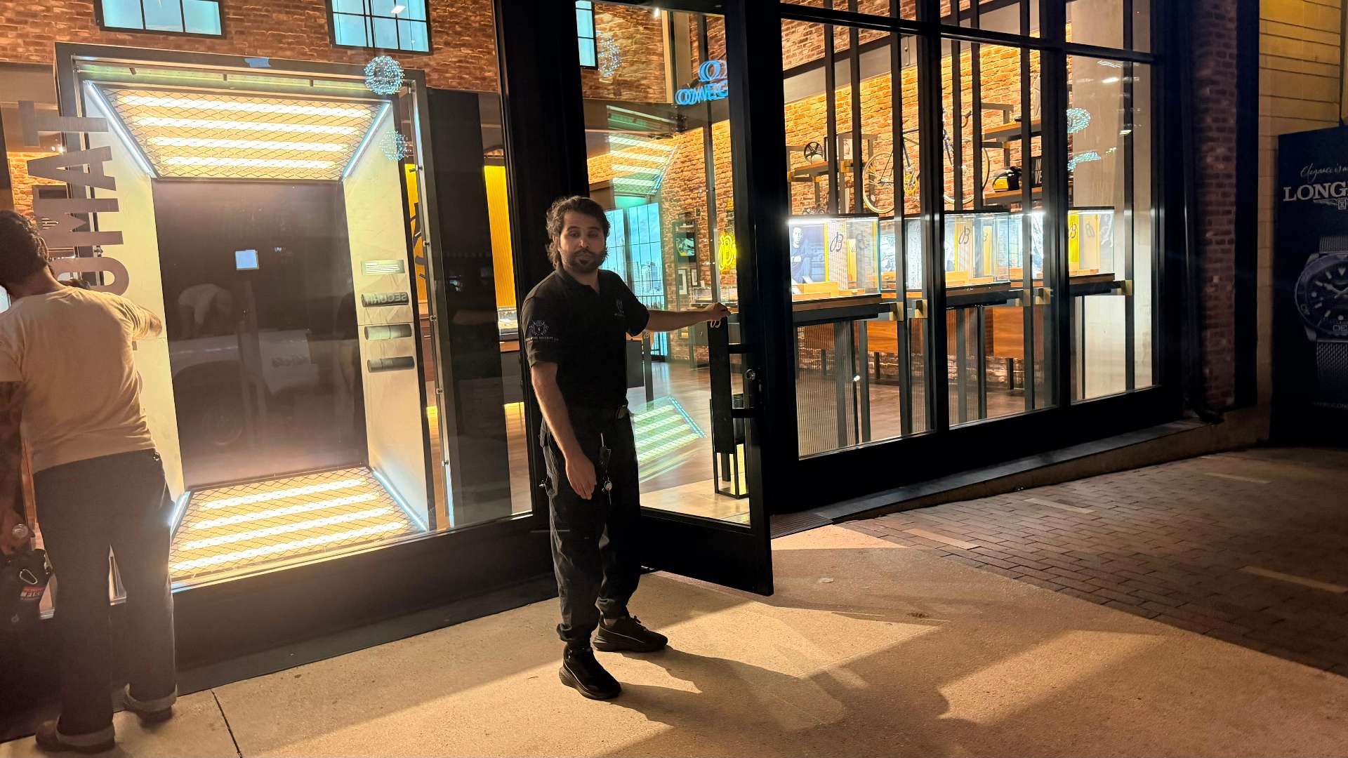 Officer controlling the storefront entrance and supporting access control during construction operations.