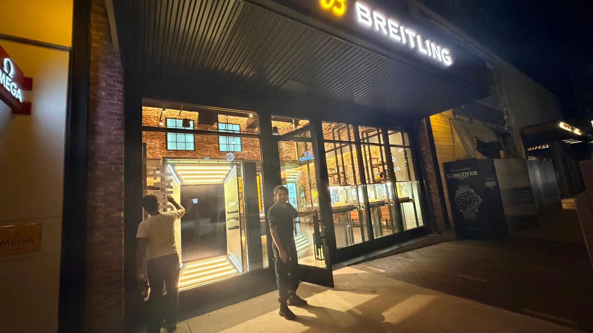 Wide exterior view of the luxury retail storefront under Shield Spire Security coverage at night.