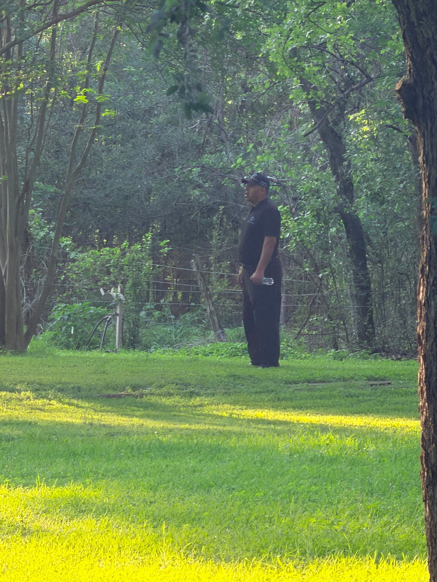 Shield Spire Security officer standing watch in a wooded section of the property, maintaining visible event monitoring.