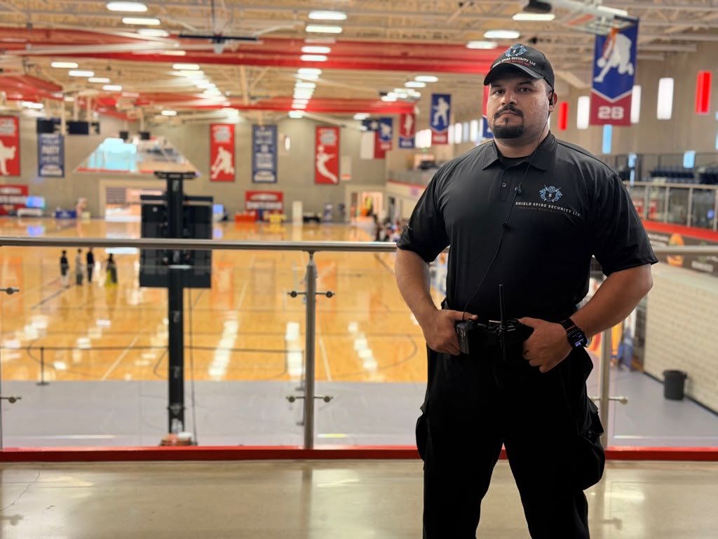 Uniformed Shield Spire Security officer overlooking the event floor during a large indoor community event in Round Rock, Texas.