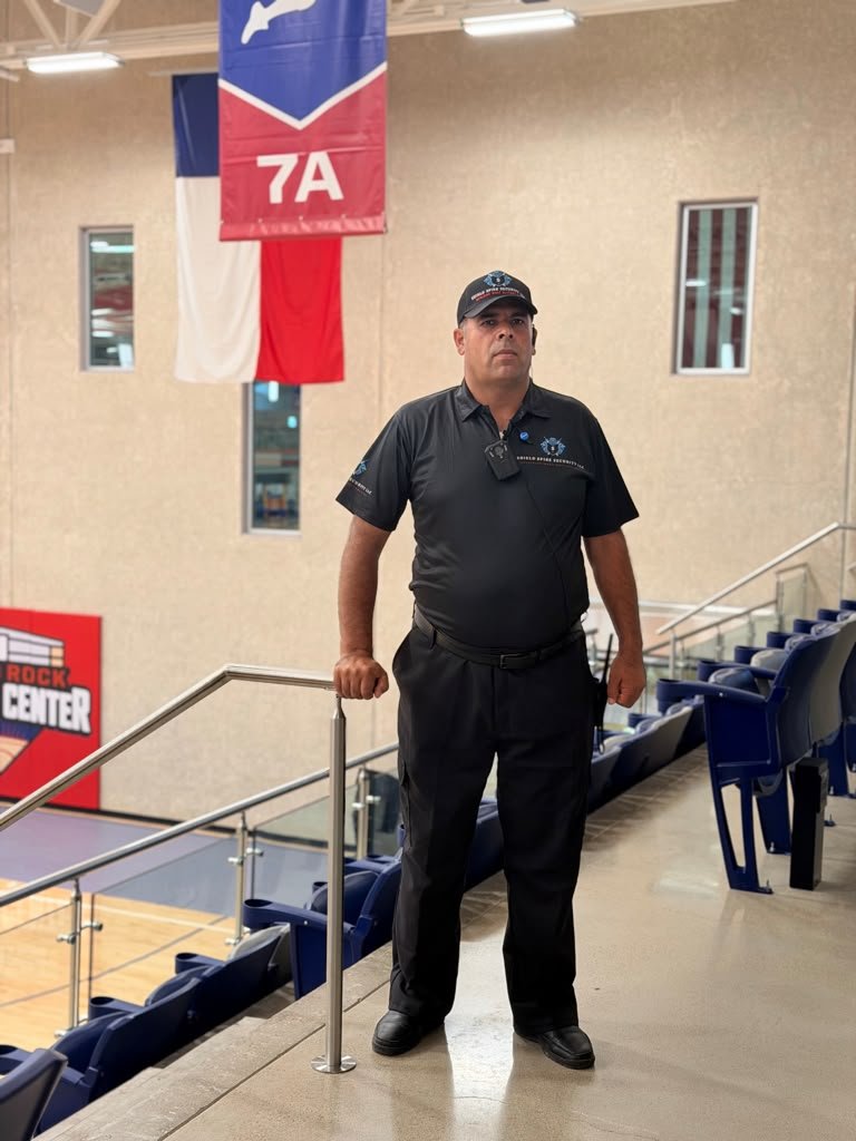 Full-body view of a uniformed officer positioned near the venue seating area.