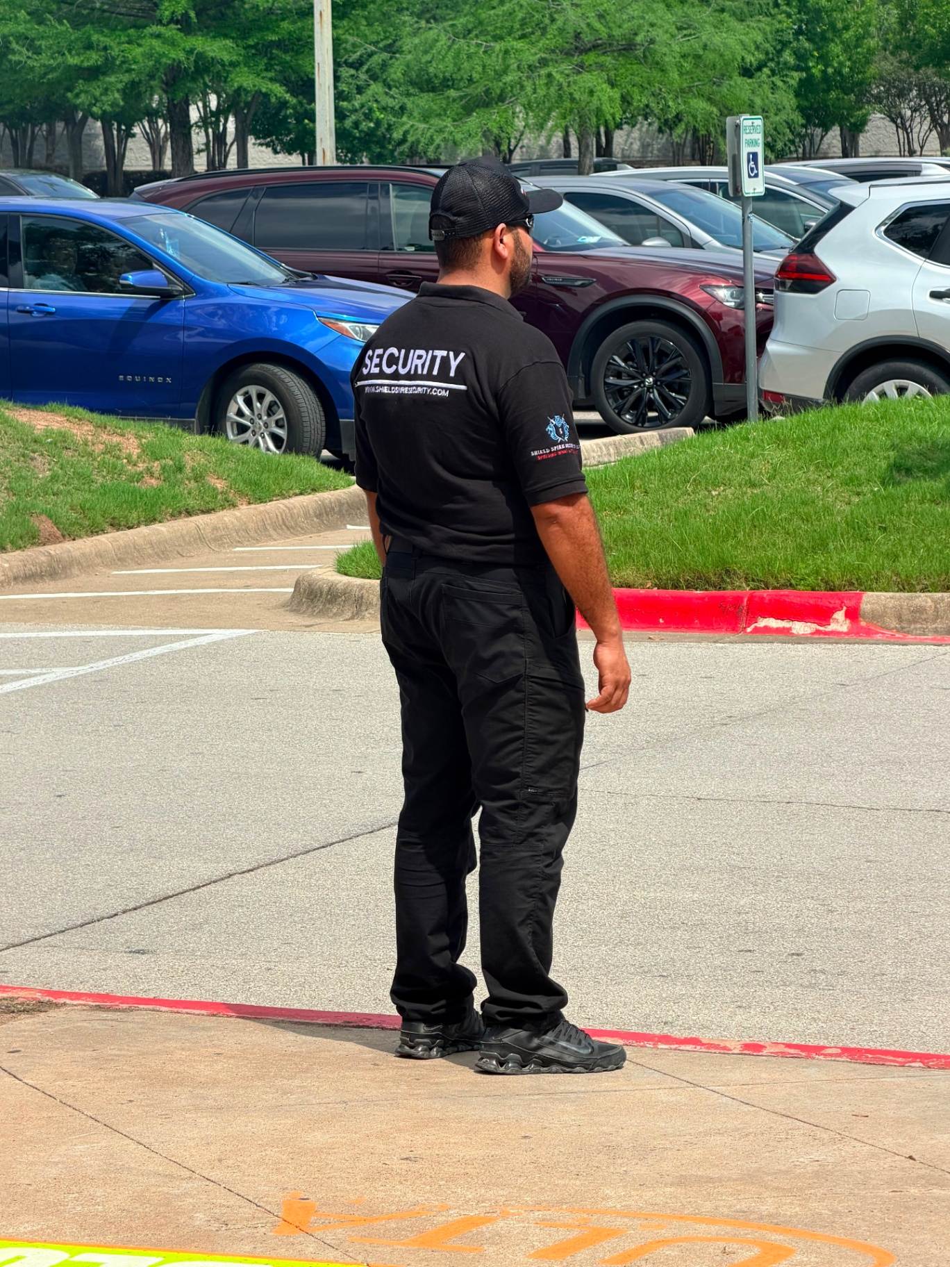 Oficial de Shield Spire Security con la identificación SECURITY visible en el uniforme, monitoreando el área de llegada de invitados en un evento promocional minorista de encuentro con una celebridad en el sur de Austin, Texas.
